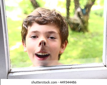 Preteen Handsome Boy Pressed Nose Against The Window Glass Close Up Smiling Portrait