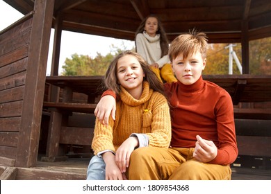 Preteen Kids, Boy And Girl Hugging In Fall Park With Lake.  Friends Wearing Warm Knit Sweaters