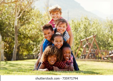 Pre-teen School Friends Lying A Pile In A Park