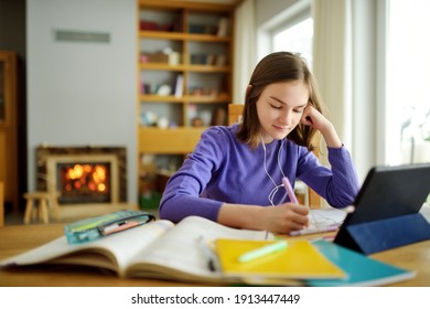 Preteen schoolgirl, die ihre Hausaufgaben mit digitalen Tablets zu Hause macht. Kind, das Gadgets zum Lernen benutzt. Bildung und Fernunterricht für Kinder. Unterricht während der Quarantäne. Bleiben Sie zu Hause Unterhaltung.