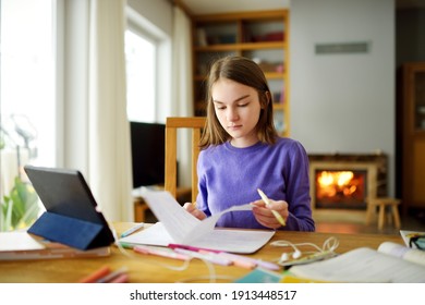 Preteen Schoolgirl Doing Her Homework With Digital Tablet At Home. Child Using Gadgets To Study. Education And Distance Learning For Kids. Homeschooling During Quarantine. Stay At Home Entertainment.