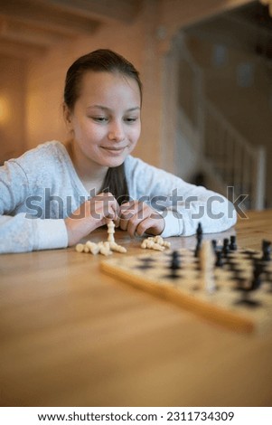 Similar – lifestyle shot of smart kid girl playing checkers at home