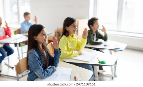 Preteen students raised hands up, sitting in classroom, group of pupils in education building school, participating classroom concept. - Powered by Shutterstock