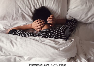 Preteen tween boy covering ears with his hands in bed, ADHD, Autism,sleep disorder, mental health in children, not want to hear, wake up kid for school , teen autism down syndrome awareness concept
