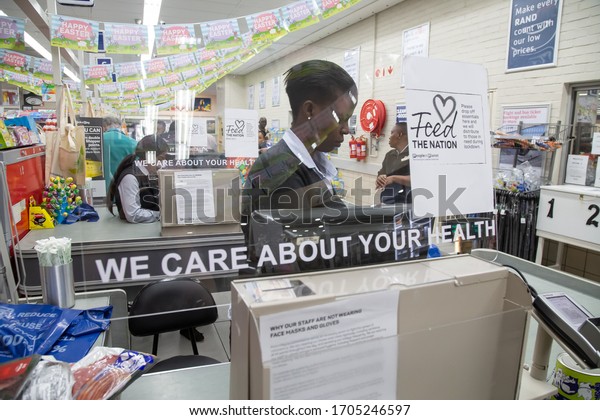 Pretoria, Gauteng, South\
Africa - 04 14 2020,staff behind protective plexiglass panel\
Grocery store counter we care about your health out of focus and\
with grain