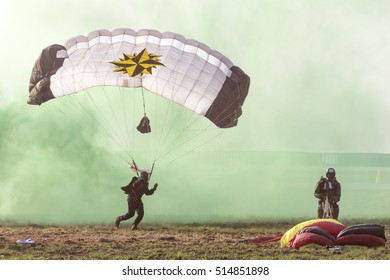 PRETORIA, SOUTH AFRICA-SEPTEMBER 17 2016: A Special Forces Parachutist Landing In Green Smoke At The African Air Defense Show At AFB Waterkloof