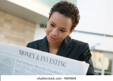 A pretty african american business woman reading the newspaper - Powered by Shutterstock