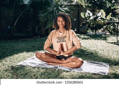 Pretty African American Woman Sitting On Green Grass Doing Yoga. T-shirt With Sign 