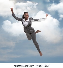 Pretty african businesswoman flying in the sky and clouds. Successful business dreaming concept