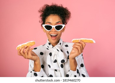 Pretty  African  Female With Suprice Face   Holding Sweets And Posing Over Pink Background. 