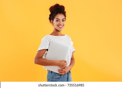 Pretty African Lady Holding Laptop And Smiling To Camera Isolated Over Yellow