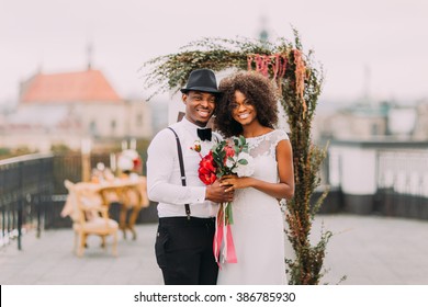 Pretty African Wedding Couple Cheerfully Smiling And Holding Hands