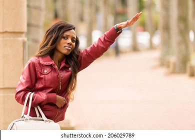 Pretty African Woman Hailing A Taxi Cab