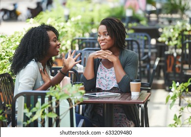 Pretty African-American Woman Telling Story To Her Female Friend