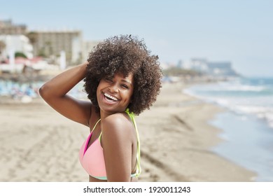 Hübsch Afro-Amerikanerin, die am Strand lacht