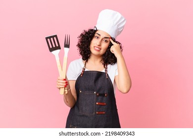 Pretty Arab Woman Feeling Confused And Puzzled, Showing You Are Insane. Barbeque Chef Concept