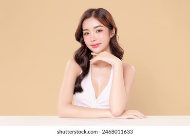 Pretty Asian beauty woman curly long hair with Korean makeup glowing face and healthy facial skin portrait smile on isolated beige background. Cosmetology ,Plastic surgery. - Powered by Shutterstock