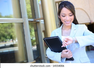 A Pretty Asian Business Woman Looking At Watch At Office Building