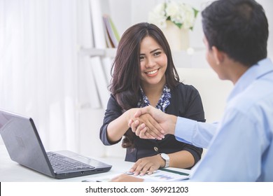 Pretty Asian Business Woman Shaking Hands With Businessman In Her Office During Meeting