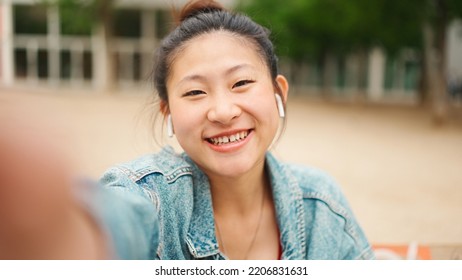 Pretty Asian Girl Smiling Recording Content For Her Video Blog Enjoying Good Day On The Street. Young Japanese Woman Looking Happy Walking Outdoors