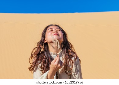 A Pretty Asian Girl Sunbathing Under Sun In The Desert