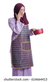 A Pretty Asian Muslim woman hold a cooking food. Housewife conceptual.
