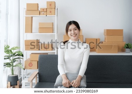 Pretty Asian small business shop owner working in her room, checking and packing orders to her customers.