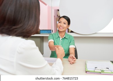 Pretty Asian Spa Salon Owner Greeting Client