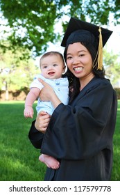 A pretty asian woman with baby boy at graduation ceremony