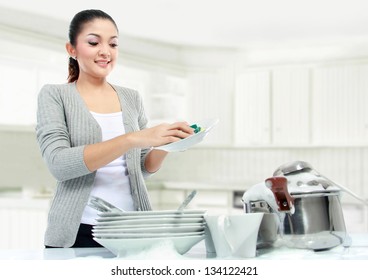 pretty asian woman doing house work, washing dishes