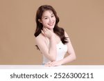 Pretty Asian woman model perfect clear fresh skin smile on isolated beige background. Portrait female beauty blogger make up artist in studio. Skincare, plastic surgery, spa concept.