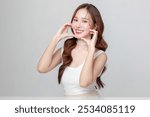 Pretty Asian woman model perfect clear fresh skin smile on isolated grey background. Portrait female beauty blogger make up artist in studio. Skincare, plastic surgery, spa concept.