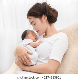 Pretty asian woman smile and holding a newborn baby in her arms. Happy family. Asia mother lifting and looking her adorable infant baby on white. love people concept - Shutterstock ID 2174813901