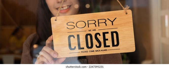 Pretty asian young owner retail, coffee shop woman turning sign board to closed after finished work, job and protection to pandemic of coronavirus. Close store due to lockdown, quarantine of covid. - Powered by Shutterstock