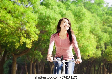 Pretty Asian Young Woman Riding Bike In The Park