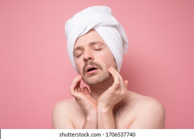 Pretty Attractive Man Beautify Making Face Massage For Better Male Macho Appearence. Studio Shot On Pink Wall.