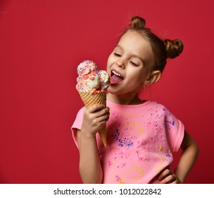 Pretty Baby Girl Kid Eating Licking Big Ice Cream In Waffles Cone With Raspberry Happy Laughing On Red Background