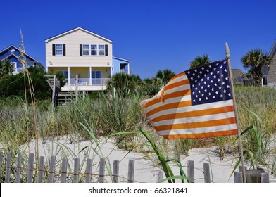 Pretty Beach Scene With Rental Home, Dune And American Flag.