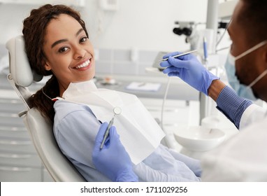 Pretty Black Happy Woman In Dentist Chair Ready For Regular Check Up In Modern Stomatological Clinic