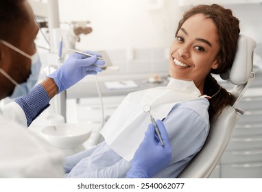 Pretty black happy woman in dentist chair ready for regular check up in modern stomatological clinic - Powered by Shutterstock