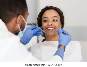 Pretty Black Lady In Dentist Chair Looking At Her Doctor With Smile, Close Up