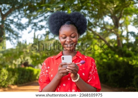 pretty black woman look very excited and rejoices while looking at her phone