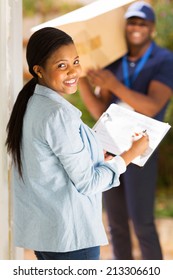 pretty black woman signing document for receiving package