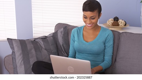 Pretty Black Woman Using Laptop On Couch