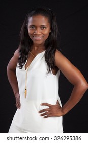 Pretty Black Woman In White Outfit, Smiling With Hands On Hips