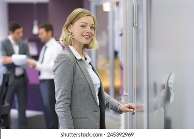 Pretty blond businesswoman open de door in modern office. Concept - Powered by Shutterstock