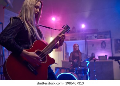 Pretty blond female playing electric guitar during stage performance - Powered by Shutterstock