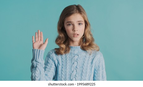 Pretty Blond Wavy Haired Teenage Girl Waving Goodbye To Friend Looking Sad Isolated On Blue Background. Bye Bye Expression