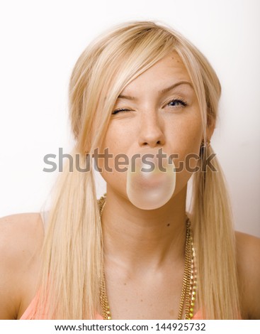 pretty blond woman blowing gum bubbles