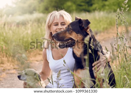 Similar – Pretty blond woman with her two dogs